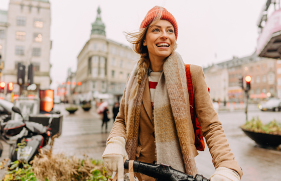 Smiling woman riding a bike in a European city