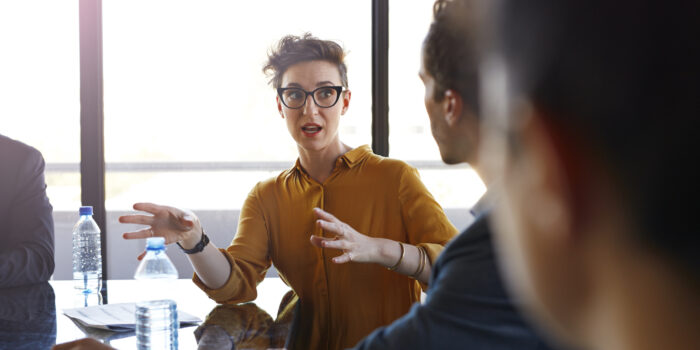 Businesswoman explaining to coworkers at meeting