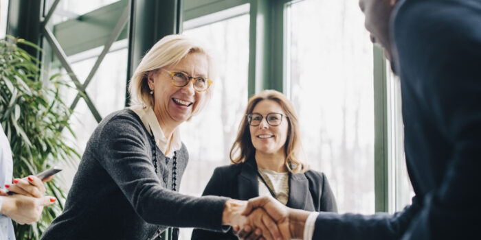 Senior businesswoman greeting colleagues during conference