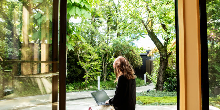 A female guest working on the porch of the guesthouse where she stayed during her trip to Japan.