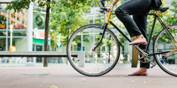 Legs of a young businesswoman on a bicycle