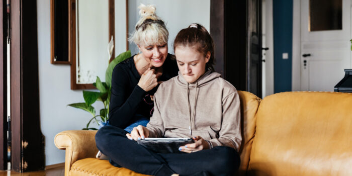 Single Mom Helping Daughter With Homework In Living Room