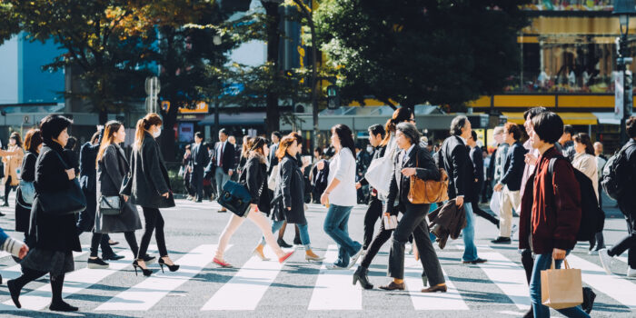 Crowd of busy commuters crossing street in Shibuya crossroad, Tokyo