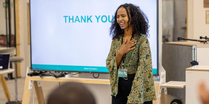 Young businesswoman saying thank-you to audience after seminar. Happy businesswoman smiling and saying thank-you to her team in office.