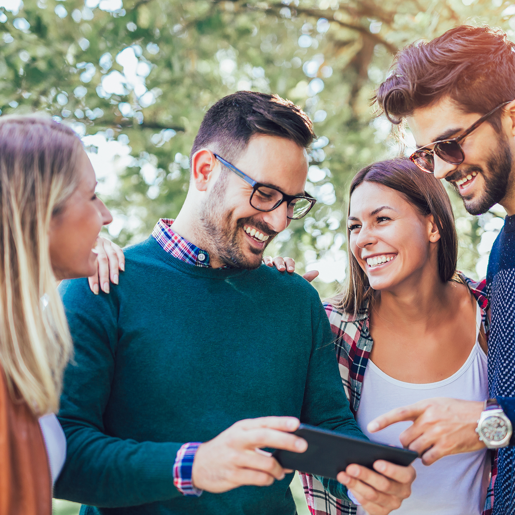 Group of happy people looking at a smartphone