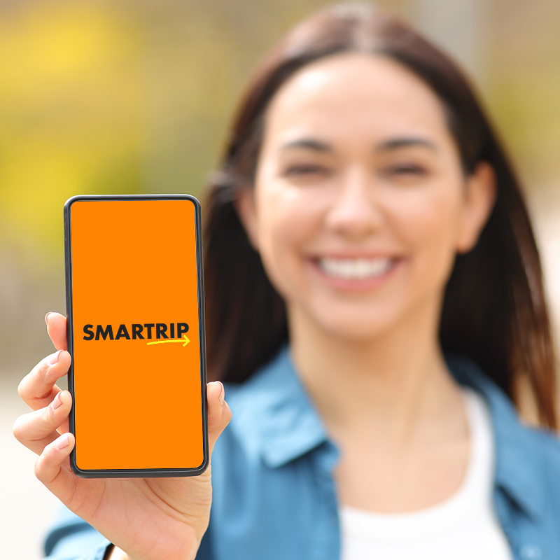 Woman holding up her smartphone and the splash screen of the SMARTRIP app is opened