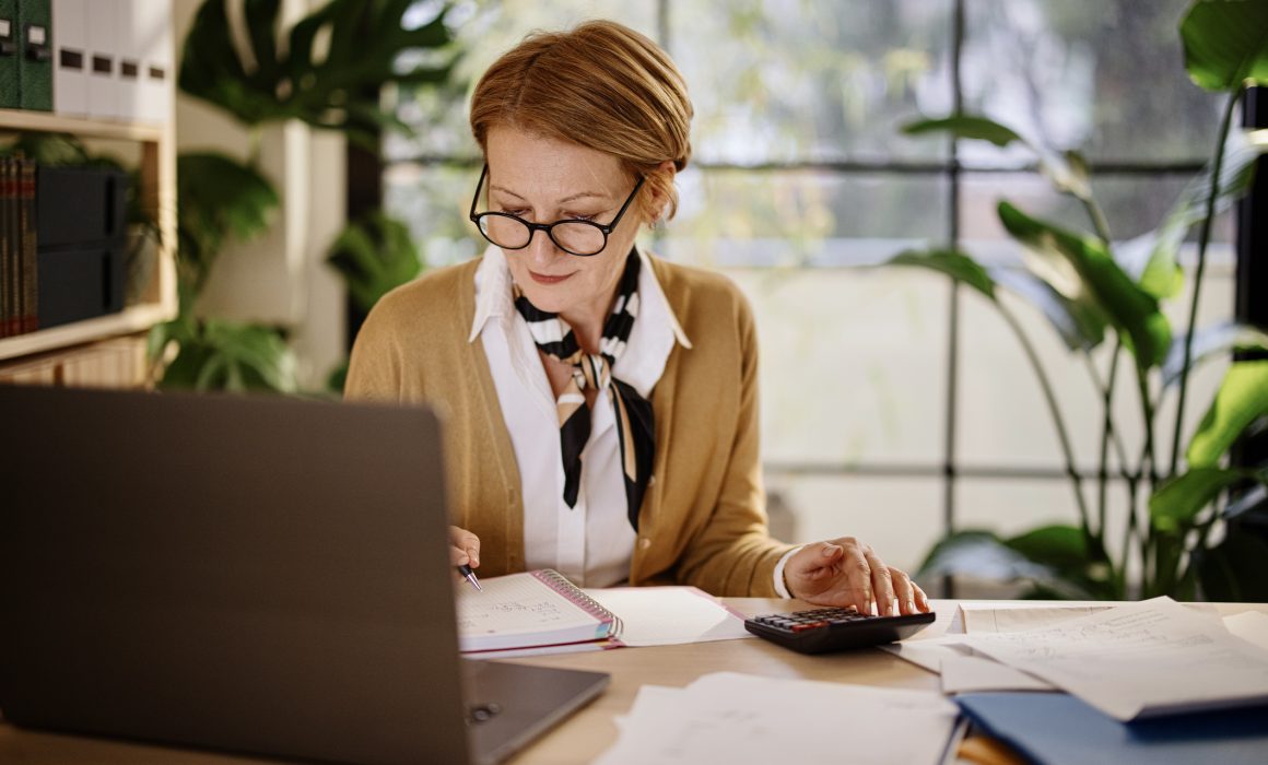 Mature businesswoman calculating finances in an home office