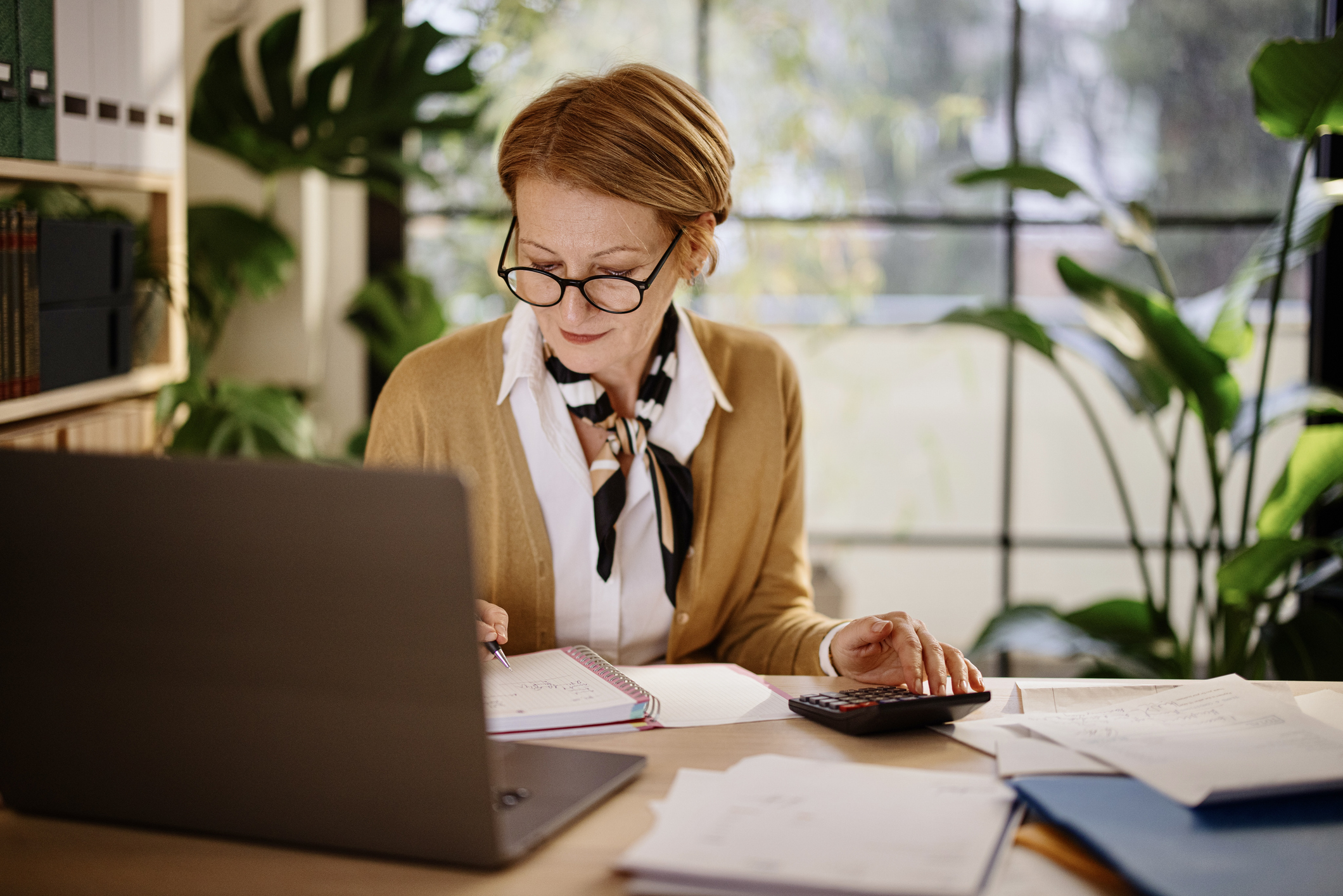 Mature businesswoman calculating finances in an home office