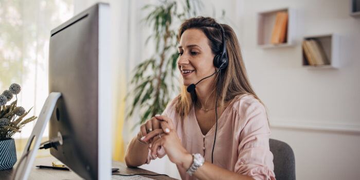 Woman working from home on computer and having remote meeting