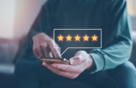 Person holding a smartphone giving 5 star review