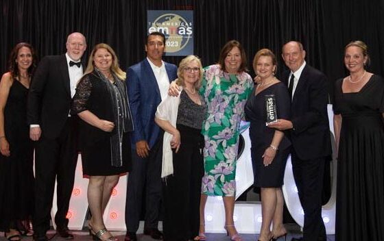 Group on stage at the America's emmas holding a trophy